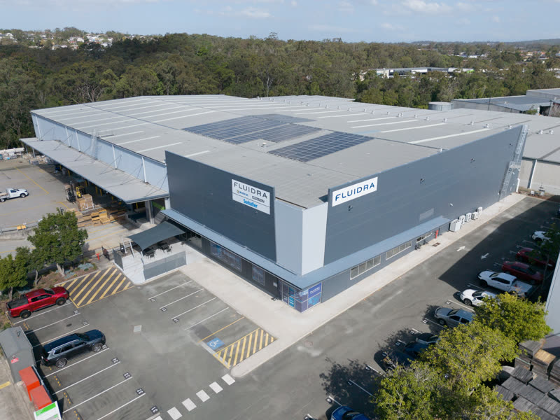 An industrial building from above, the office on the corner and parking out front